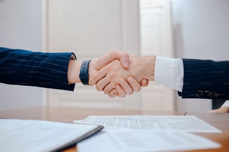 A consultant and client shaking hands after agreeing a UAE business setup engagement